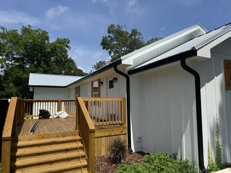 Black seamless gutters and downspouts installed by LePierre Roofing on a Nassau County home