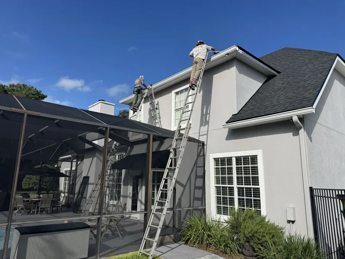LePierre Roofing Gutter Division crew installing seamless gutters on a two story home